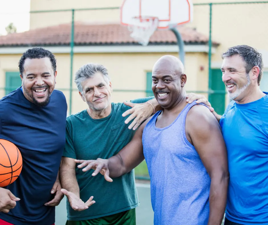 4 older men smile before they play a basketball game.