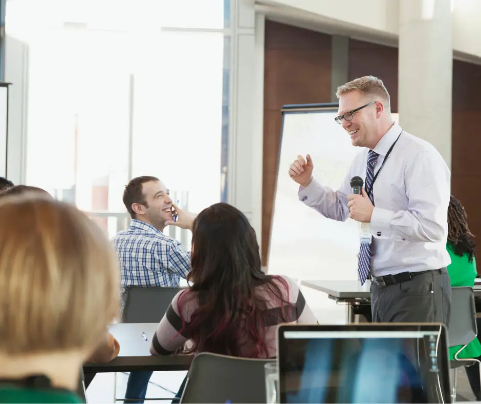 People watch a speaker during a work meeting. 